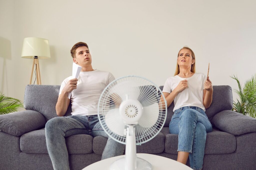 Couple on couch trying to stay cool in the summer heat